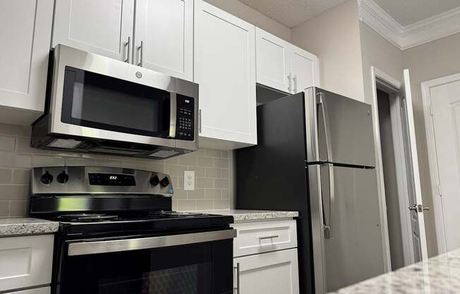 A kitchen with a black stove top oven and a black microwave above it.