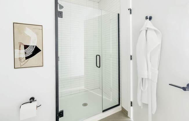 A white towel is hanging on a hook on a white wall.