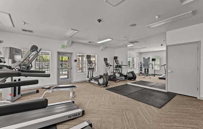 A gym with treadmills, exercise bikes, and other equipment.