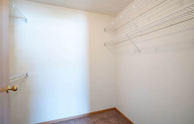 A room with a door and a brown carpet. Fargo, ND Stonebridge Apartments