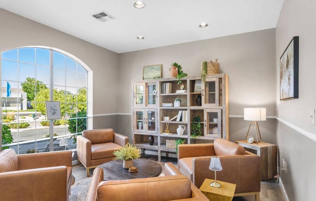 a living room with brown leather furniture and a large window