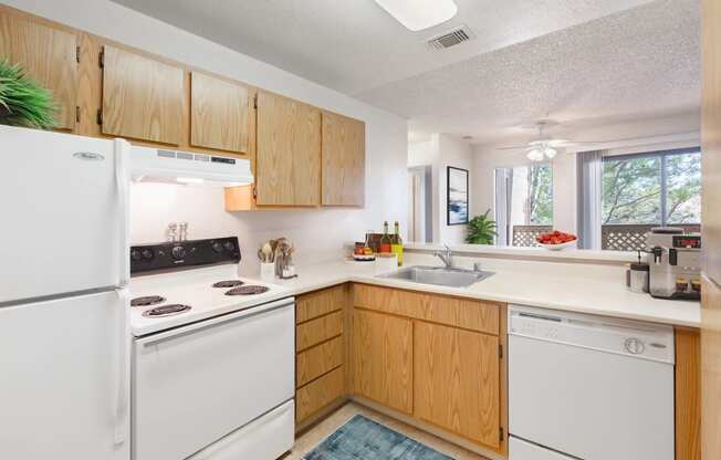 a kitchen with white appliances and wooden cabinets