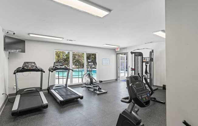 A gym with treadmills, exercise bikes, and other equipment.