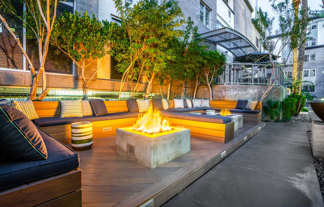 a patio with couches and a fire pit