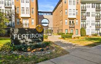 Flatiron West Trade Apartments exterior with monument sign and elevated walkway