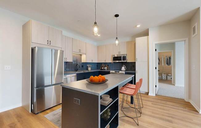 A kitchen with a refrigerator, sink, and countertop.
