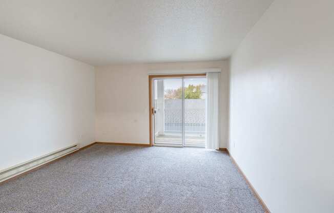 a living room with a glass sliding door. Fargo, ND Oxford Apartments