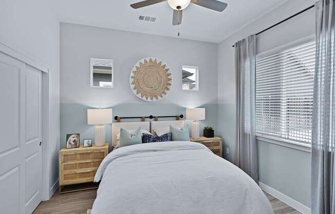 A bedroom with a bed, nightstands, and a ceiling fan.