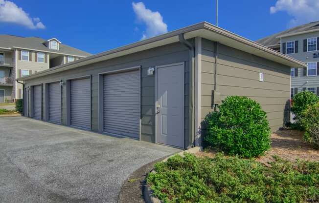 Lancaster Place Apartments in Calera Alabama photo of a row of garages with roller doors in front of an apartment building