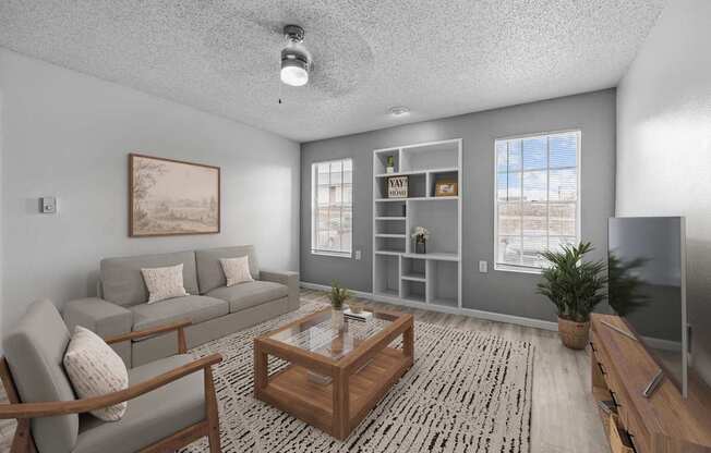 A living room with a grey couch, a wooden coffee table, and a painting on the wall.