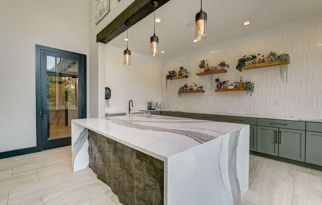 the kitchen has a large island with a marble counter top