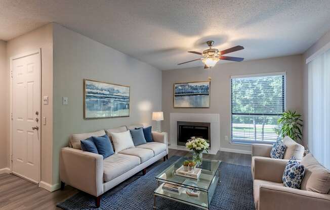 A living room with a white couch, a coffee table, and a ceiling fan.