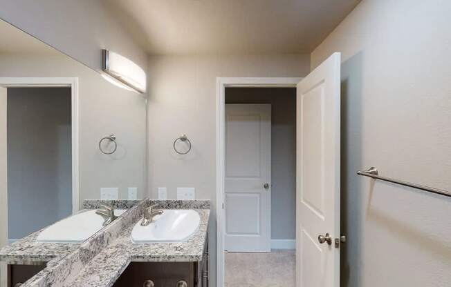 A bathroom with two sinks and a mirror.