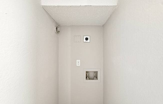 A white wall with a switch and a socket.