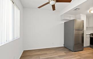 a kitchen with a stainless steel refrigerator and a ceiling fan