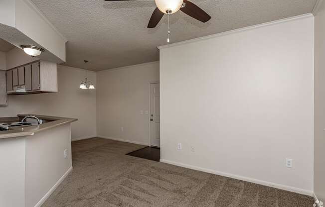 A room with a ceiling fan and a carpeted floor.