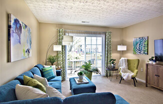 A living room with a blue couch and a green chair.