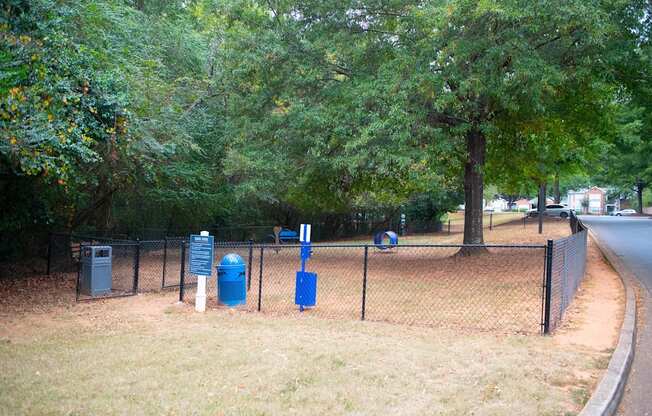 a park with a chain link fence and blue trash cans at Twenty35 at Timothy Woods, Athens, Georgia