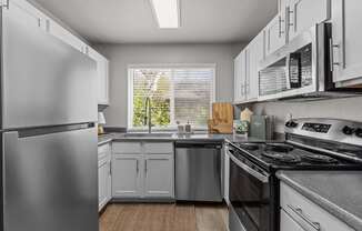 a kitchen with stainless steel appliances and white cabinets