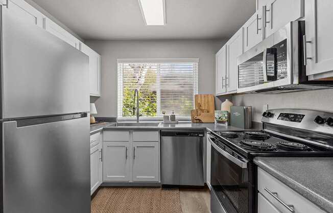 a kitchen with stainless steel appliances and white cabinets