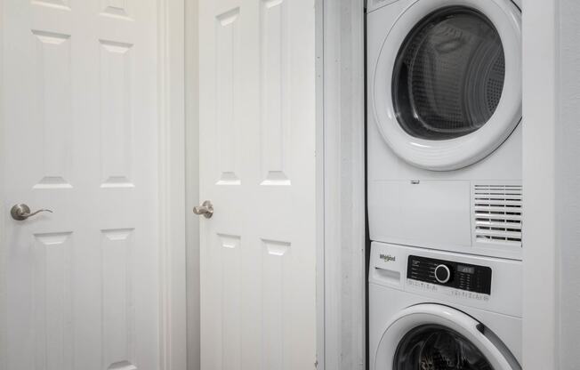 a white washer and dryer in a white laundry room
