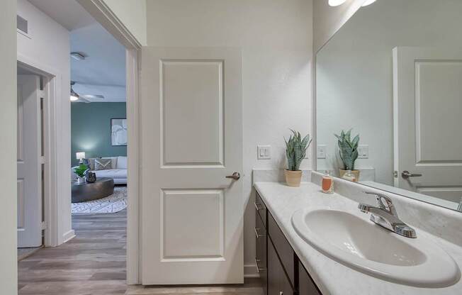 A bathroom with a white sink and a white door.