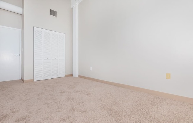 an empty living room with a door to a closet