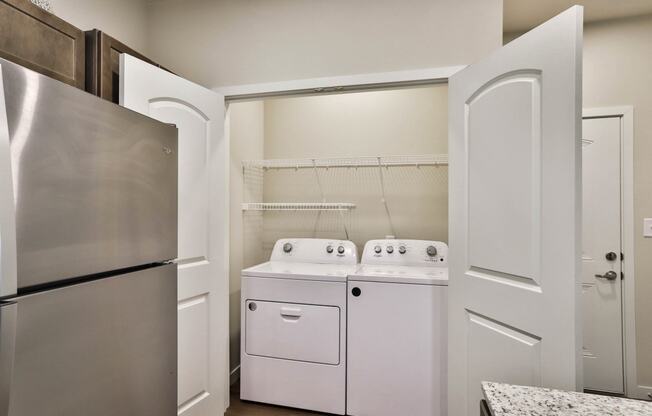 a kitchen with a washer and dryer and a refrigerator at Aventura at Hawk Ridge, Lake St Louis Missouri