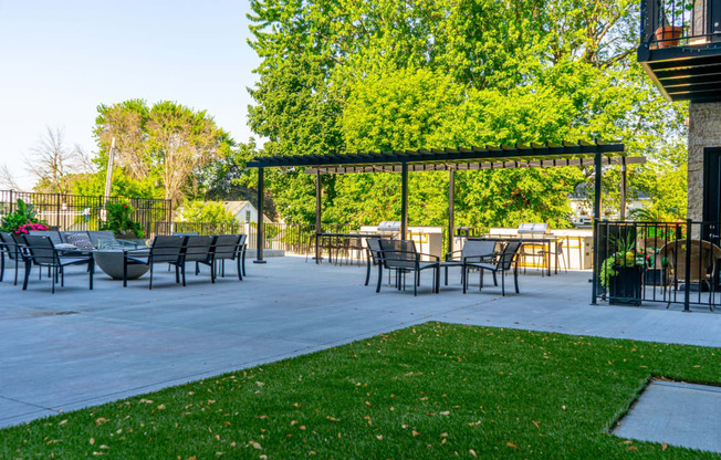 a patio with a pergola and tables and chairs