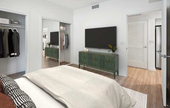 a bedroom with a bed and a television on the wall