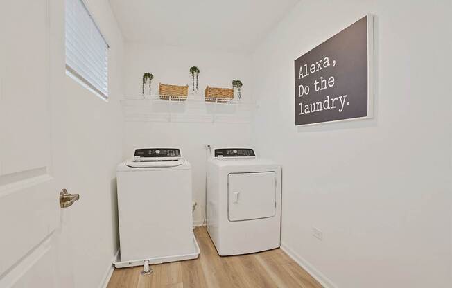 A laundry room with a sign that says "Alexa, do the laundry.".