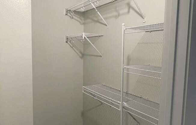 A white closet with shelves and hangers.