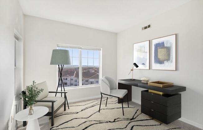 a living room with a desk and a window