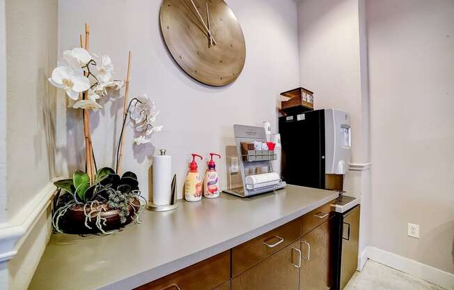 a kitchenette with a coffee machine refrigerator and sink