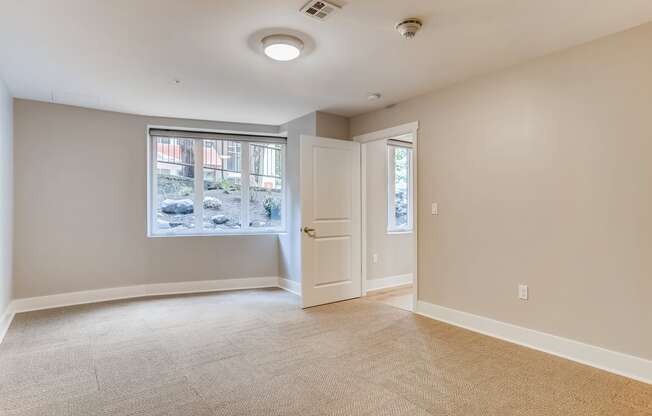 an empty living room with a window and a door