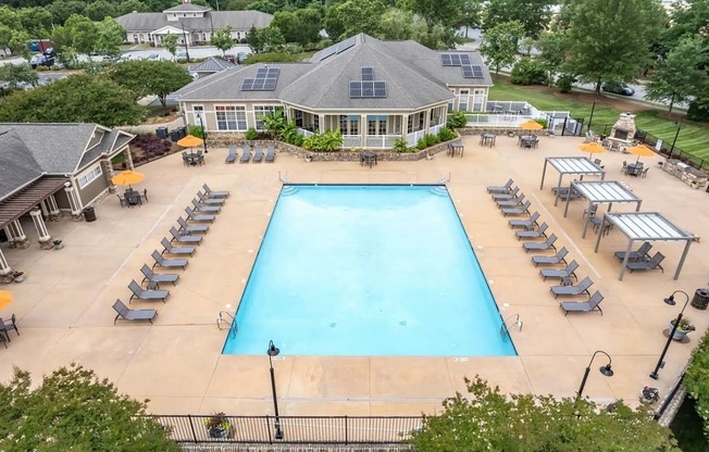 A large swimming pool surrounded by sun loungers and umbrellas.