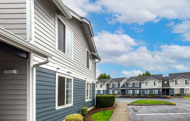 a row of houses with blue siding and a parking lot