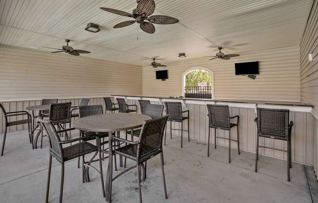A patio with a table and chairs and a ceiling fan.