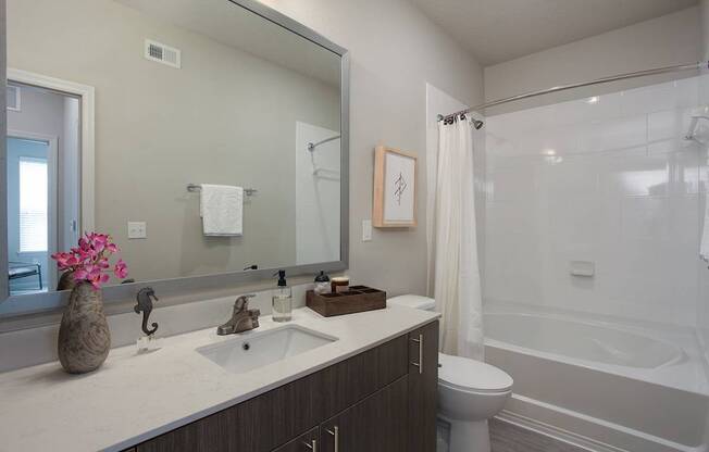 Bathrooms with quartz countertops and garden soaking tubs with curved shower rods