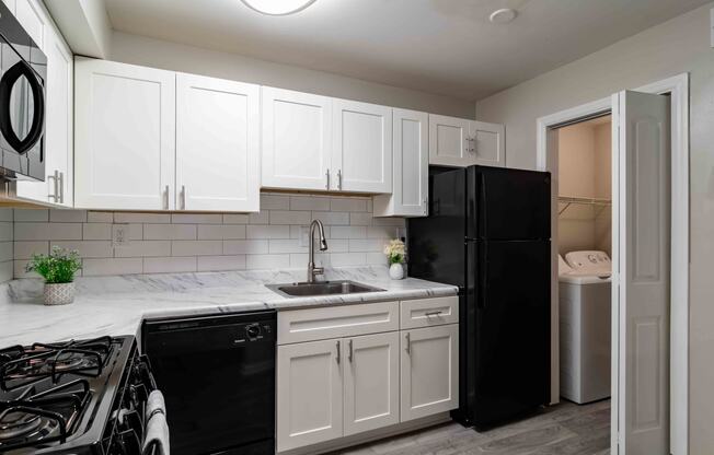 Kitchen with black appliances and open layout in renovated Atlanta rental apartment.