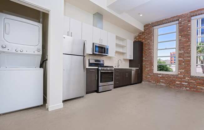 kitchen and laundry area with brick wall and large windows