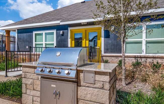 a stainless steel barbecue grill in front of a house