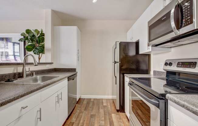 stainless steel appliances and wood inspired flooring in the kitchen