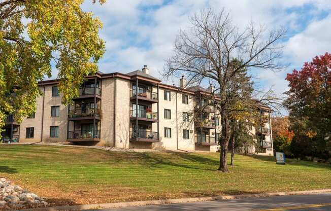 an apartment building on a hill with a tree in front of it