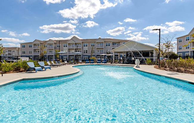 A large swimming pool in front of apartment buildings.