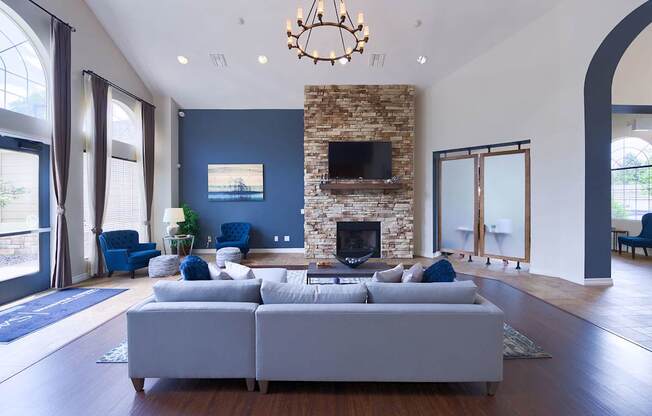 A living room with a white couch and a stone fireplace.