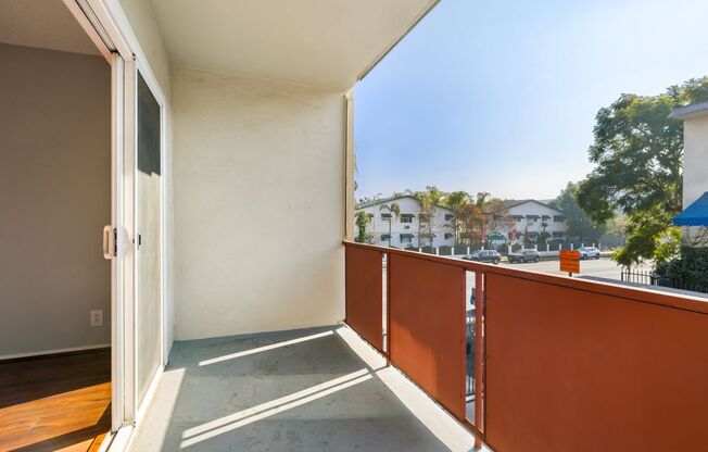 A balcony with a white door and orange railing.