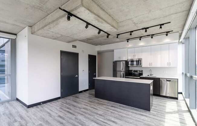A modern kitchen with a black countertop and stainless steel appliances.