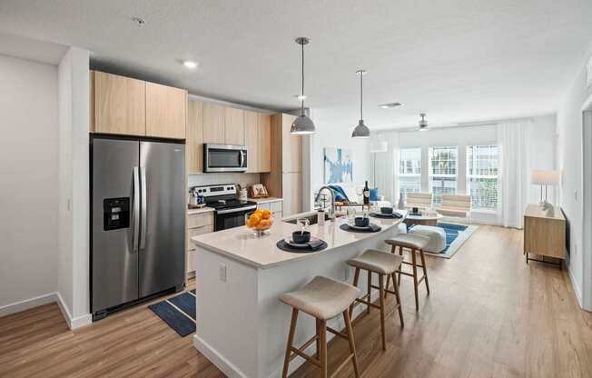 a kitchen and living room with a large island with stools at Altis Grand Suncoast, Land O' Lakes, 34638