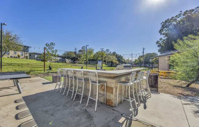 a patio with a table and chairs in a park  at Sunset Ridge, Texas, 78209